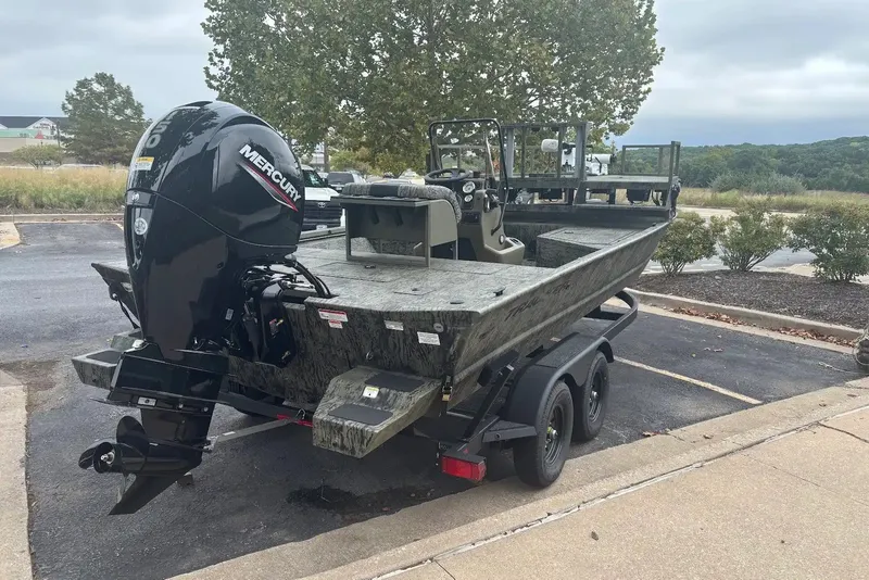 Slide: The Image of 2027 Tracker Grizzly 2072 CC Sportsman boat with Mercury engine on trailer in parking lot. - 23