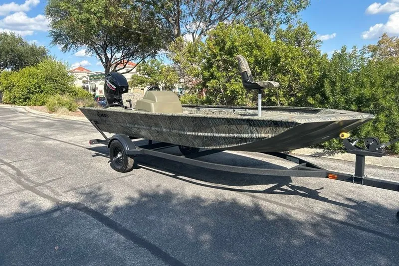The Image of 2027 Tracker Grizzly 1754 SC boat on trailer, parked outdoors under clear sky. - 0