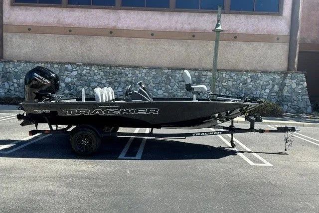 The Image of 2027 Tracker Pro Team 175 Crappie Edition boat on trailer in parking lot. - 0