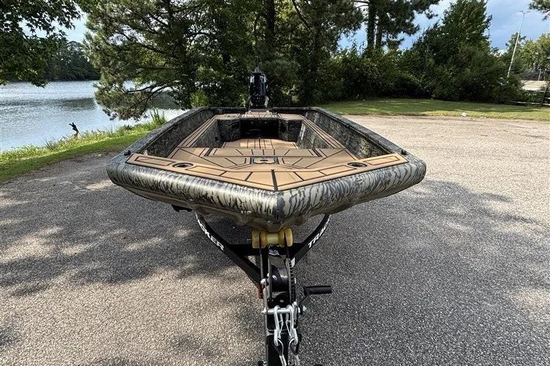 The Image of 2027 Tracker Grizzly 1650 T Prairie Wings Edition boat on trailer by a lake. - 1