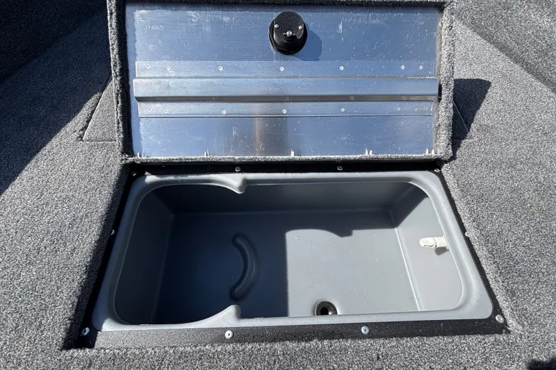 Slide: The Image of Open storage compartment in 2027 Tracker Super Guide V-16 SC boat, featuring carpeted interior. - 13