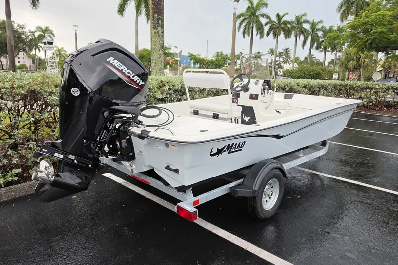 Slide: The Image of 2027 Mako Pro Skiff 17 CC boat on trailer with Mercury engine in parking lot. - 9