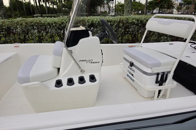 Slide: The Image of 2027 Mako Pro Skiff 17 CC boat interior with seating and steering console. - 7