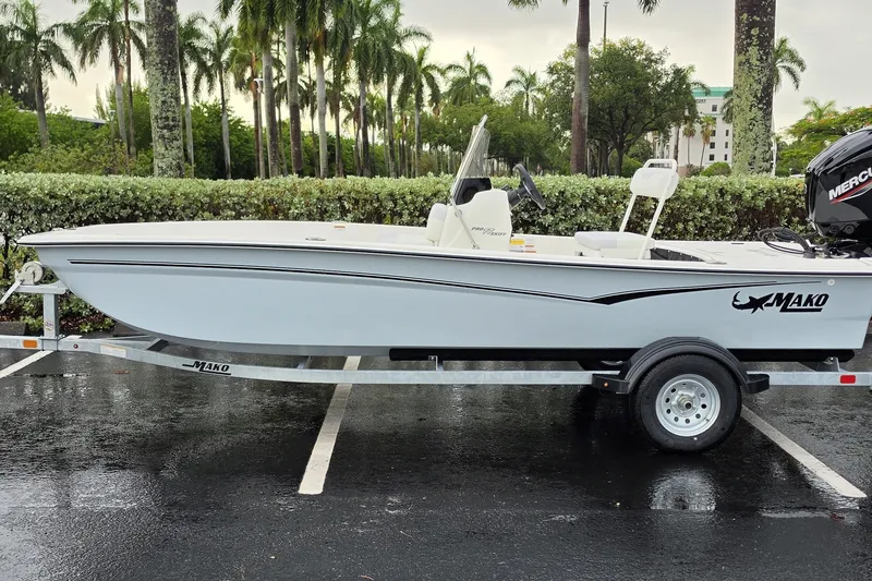 The Image of 2027 Mako Pro Skiff 17 CC boat on trailer, parked outdoors near palm trees. - 0