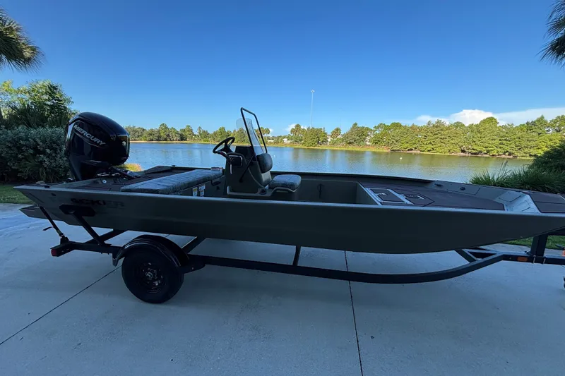 The Image of 2027 Tracker Grizzly 1860 CC boat on trailer by a scenic lake. - 0