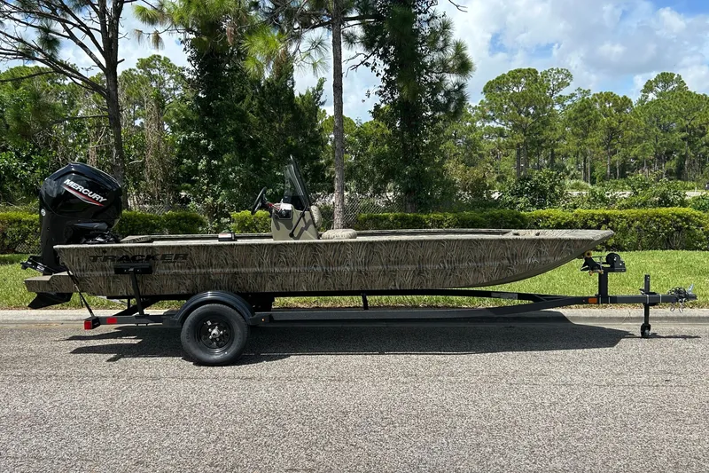 The Image of 2027 Tracker Grizzly 1860 CC boat on trailer, parked on a sunny road. - 0