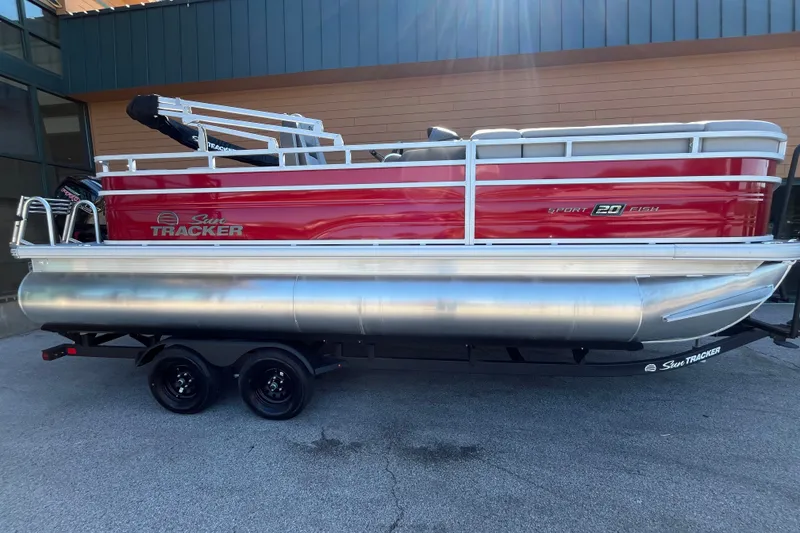The Image of 2027 Sun Tracker SportFish 20 DLX pontoon boat on trailer, red and silver design. - 0
