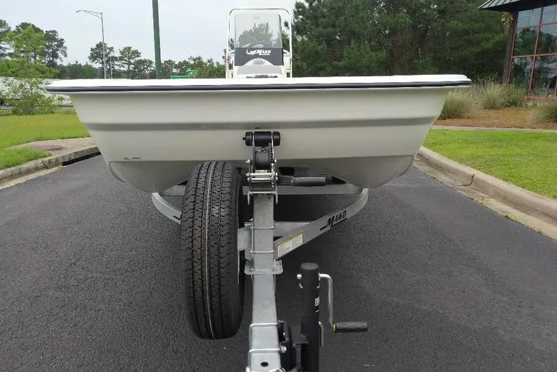Slide: The Image of 2027 Mako Pro Skiff 17 CC boat on trailer, parked on asphalt near greenery. - 8