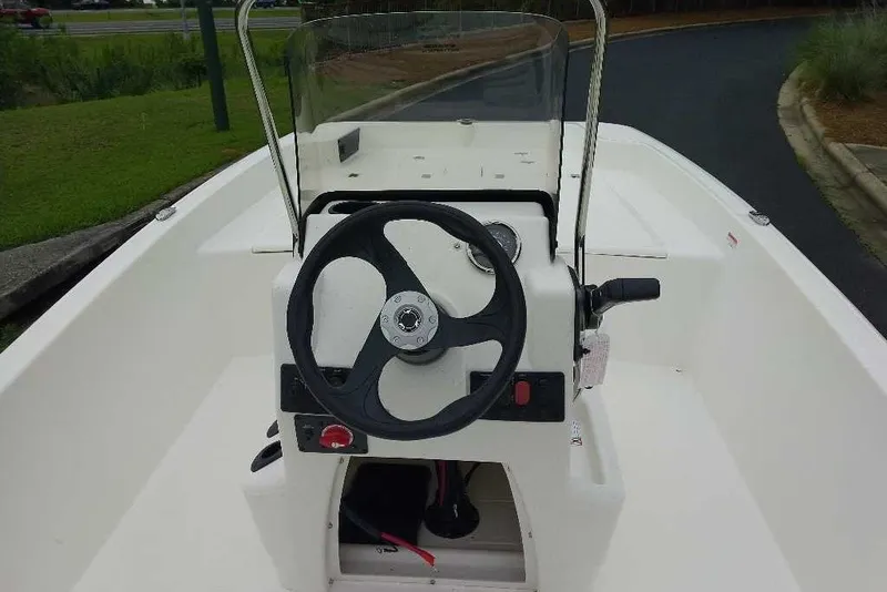 Slide: The Image of 2027 Mako Pro Skiff 17 CC boat console with steering wheel and controls. - 4