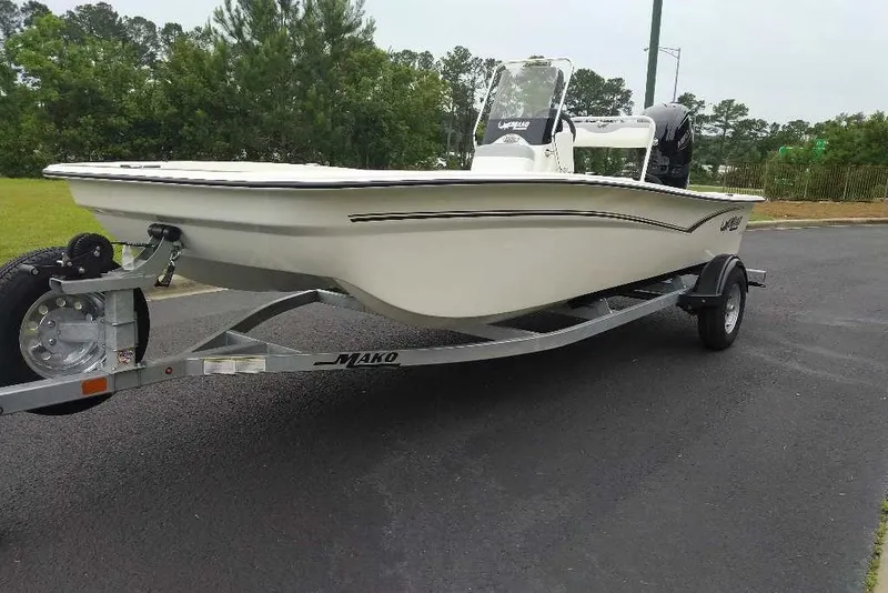 Slide: The Image of 2027 Mako Pro Skiff 17 CC boat on trailer, parked on asphalt road. - 7