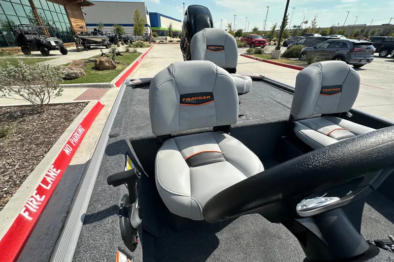 Slide: The Image of 2027 Tracker Bass Tracker Classic Limited boat with gray seats in a parking lot. - 15