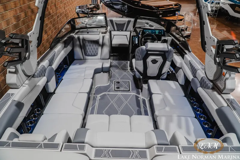 Slide: The Image of 2027 Malibu M230 boat interior with luxurious seating and modern dashboard at Lake Norman Marina. - 15