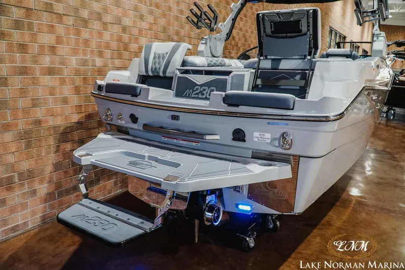 Slide: The Image of 2027 Malibu M230 boat displayed indoors at Lake Norman Marina. - 11