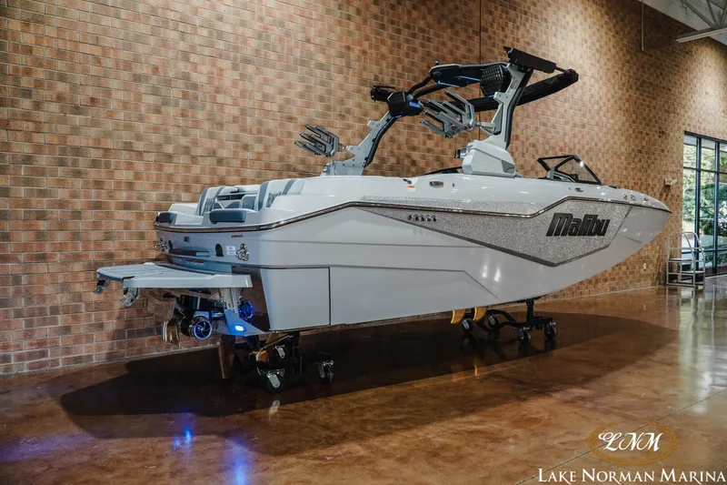 Slide: The Image of 2027 Malibu M230 boat displayed indoors at Lake Norman Marina. - 2