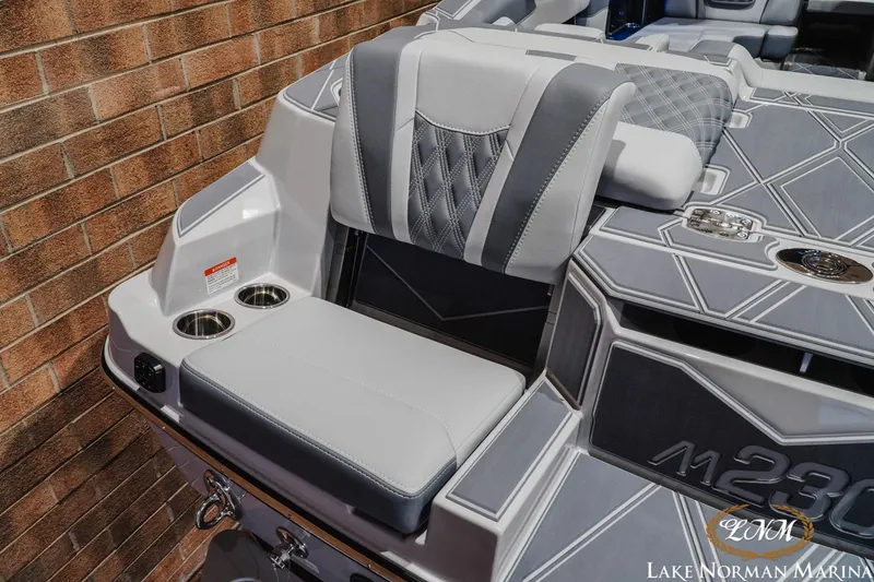 Slide: The Image of 2027 Malibu M230 boat interior with gray seating and cup holders, Lake Norman Marina. - 13