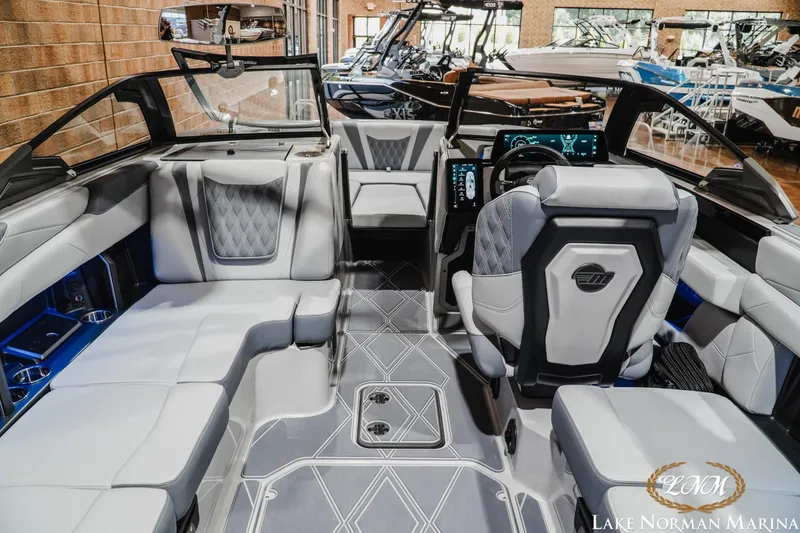 Slide: The Image of Interior of a 2027 Malibu M230 boat showcasing luxurious seating and modern dashboard. - 16