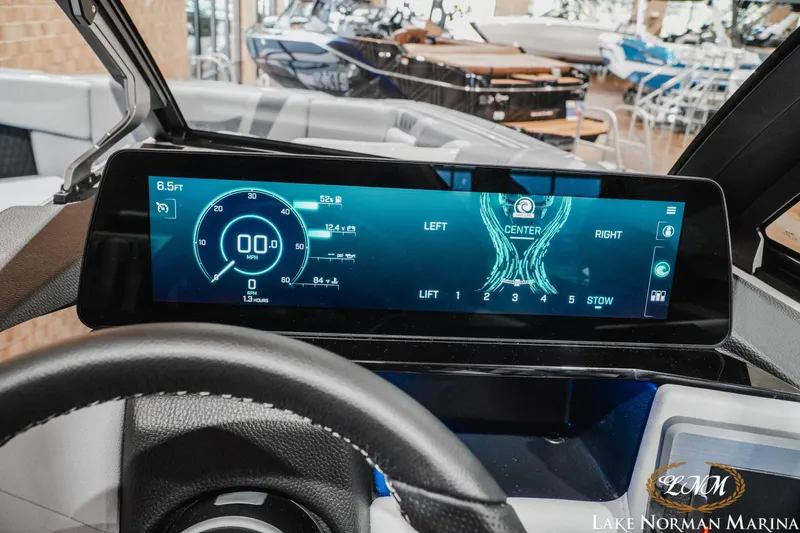 Slide: The Image of Dashboard of a 2027 Malibu M230 boat with digital display and steering wheel. - 26