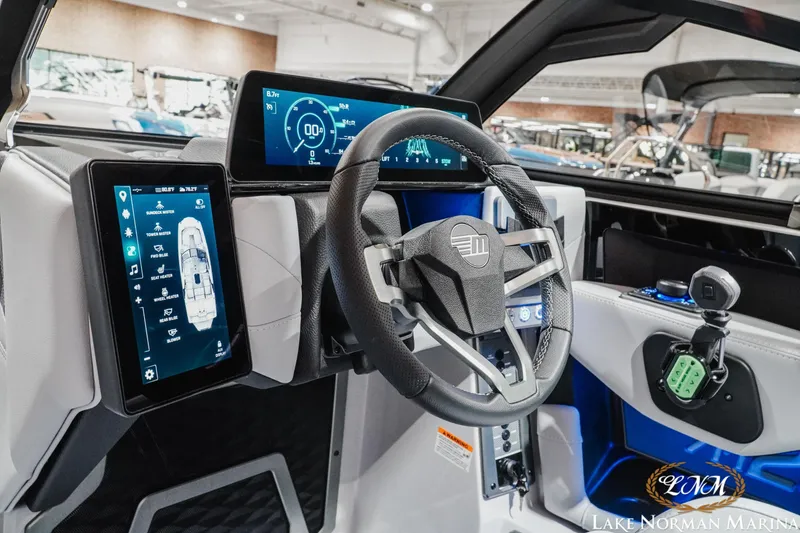 Slide: The Image of 2027 Malibu M230 boat dashboard with advanced digital displays and modern steering wheel. - 24