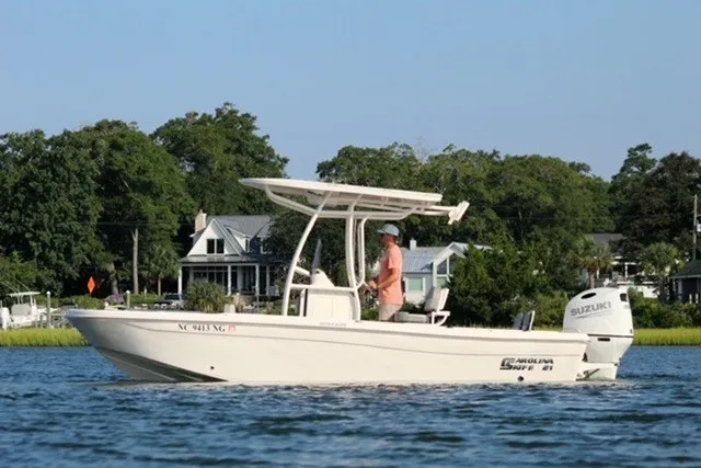 Slide: The Image of 2025 Carolina Skiff 21 Ultra Elite boat cruising on a serene lake with scenic background. - 1
