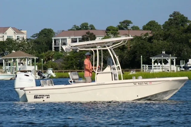 The Image of 2025 Carolina Skiff 21 Ultra Elite boat cruising on a scenic waterway. - 0