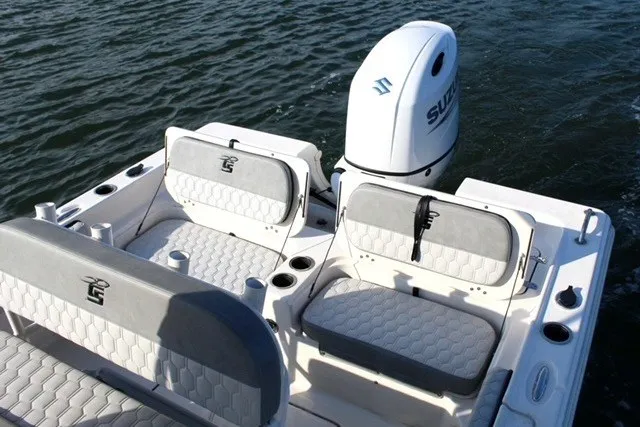 Slide: The Image of 2025 Carolina Skiff 21 Ultra Elite boat interior with seating and outboard motor on water. - 8