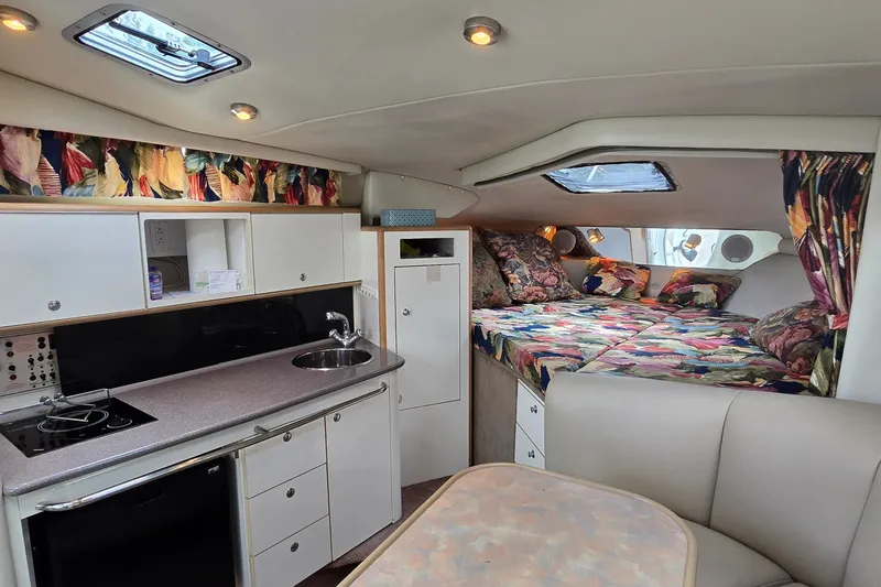 Slide: The Image of 1998 Chaparral Signature 300 cabin interior with kitchenette, bed, and seating area. - 18