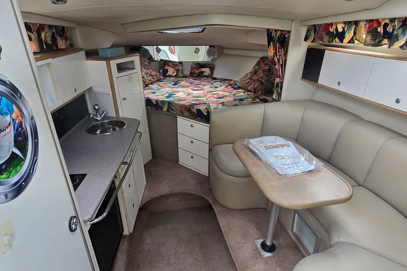 Slide: The Image of 1998 Chaparral Signature 300 cabin interior with kitchenette, seating, and bed. Cozy and well-equipped. - 17