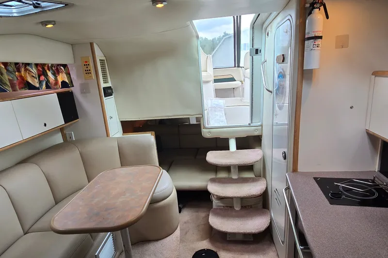 Slide: The Image of 1998 Chaparral Signature 300 interior with seating, table, stairs, and kitchenette. - 26
