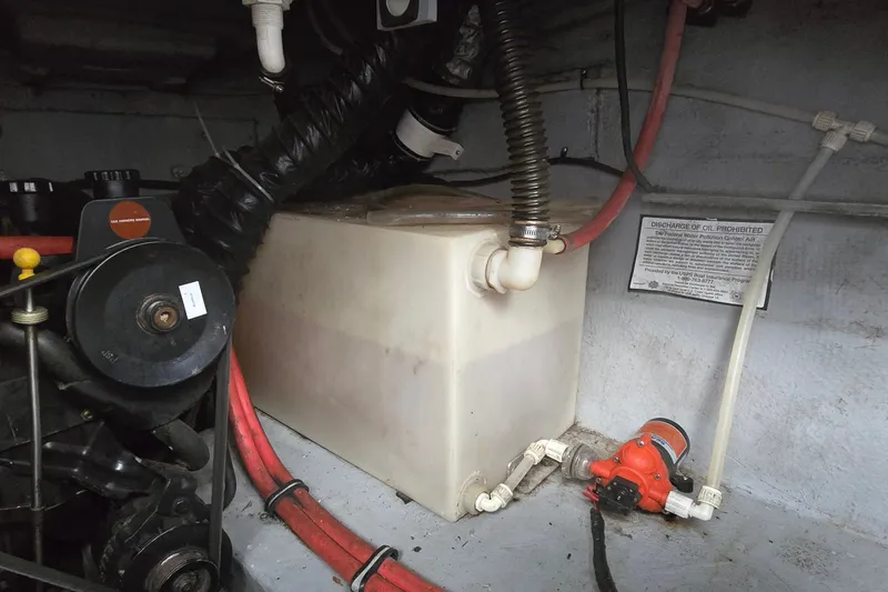 Slide: The Image of Engine compartment of a 1998 Chaparral Signature 300 boat, featuring hoses and a fluid tank. - 38