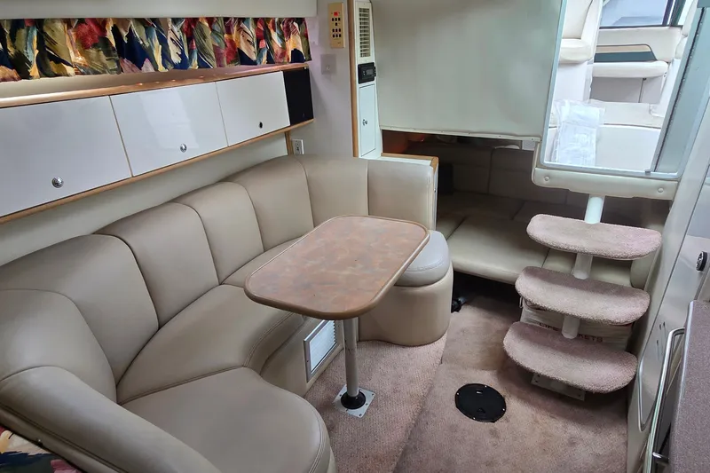Slide: The Image of Interior of 1998 Chaparral Signature 300 yacht with beige seating and wooden table. - 20