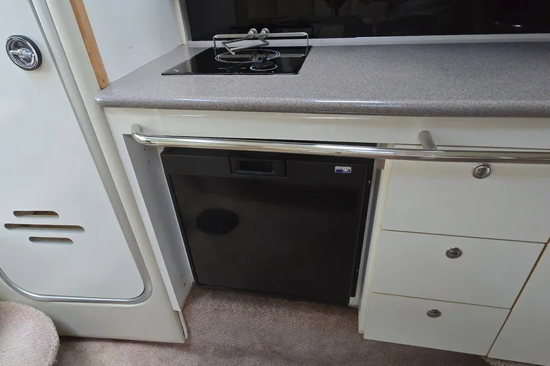 Slide: The Image of 1998 Chaparral Signature 300 boat kitchenette with stove, countertop, and storage drawers. - 30