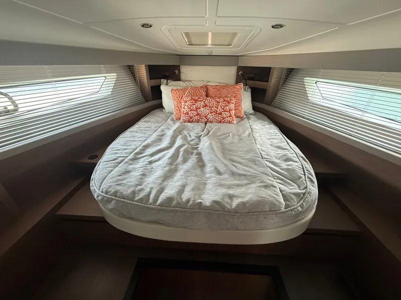 Slide: The Image of The cabin of the 2020 Beneteau Gran Turismo 40 features a cozy bed with orange pillows. - 42