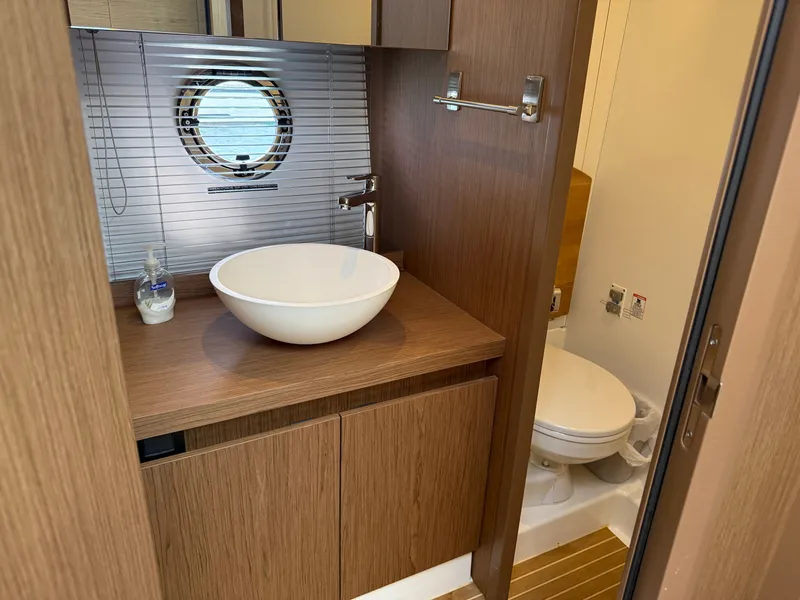 Slide: The Image of The image shows a modern boat bathroom with a round sink and a porthole. - 47
