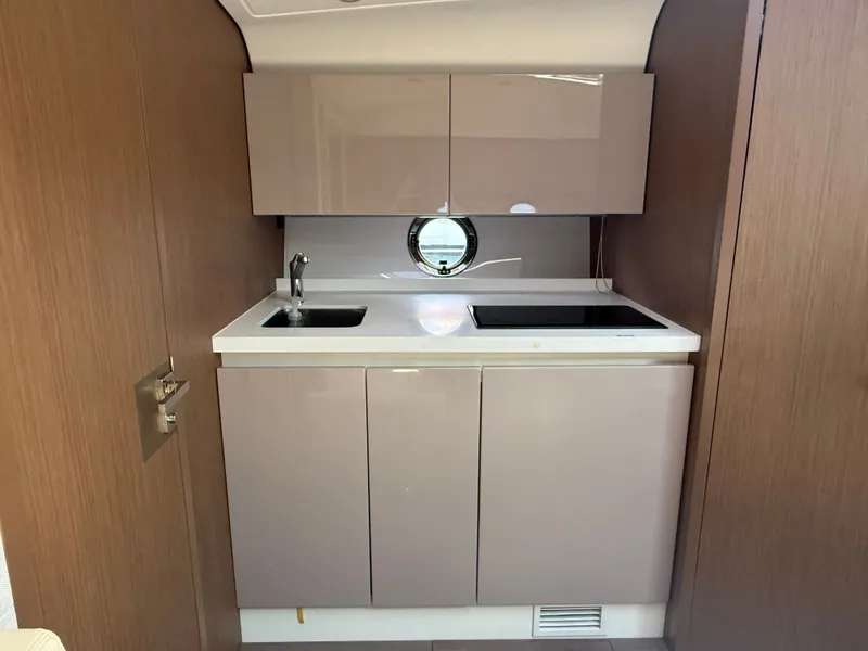 Slide: The Image of Compact boat kitchen with sink, stove, and storage, featuring a modern design. - 37