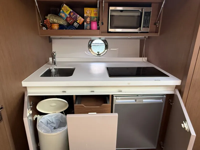 Slide: The Image of The 2020 Beneteau Gran Turismo 40 kitchen features a sink, stove, and refrigerator. - 38