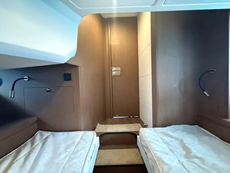 Slide: The Image of Interior of the Beneteau Gran Turismo 40 with twin beds and wooden walls. - 36