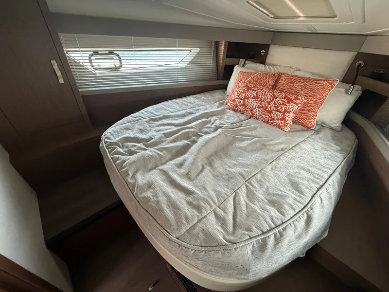 Slide: The Image of The cabin of the 2020 Beneteau Gran Turismo 40 features a cozy bed with orange pillows. - 44