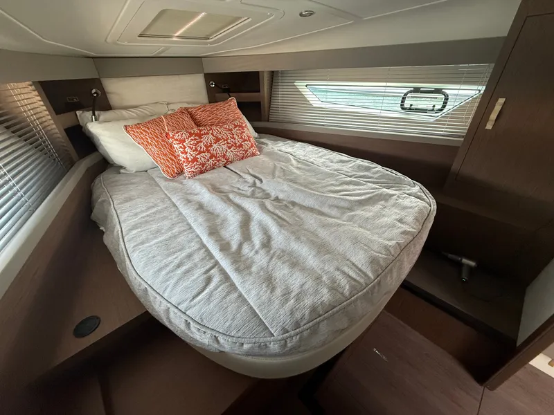 Slide: The Image of The cabin of the 2020 Beneteau Gran Turismo 40 features a cozy bed with pillows and a side window. - 43