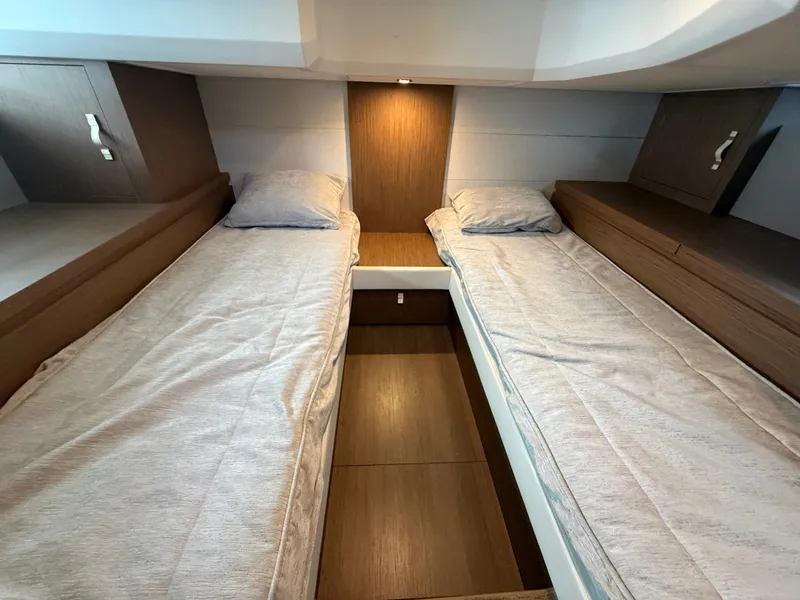 Slide: The Image of The 2020 Beneteau Gran Turismo 40 cabin features two single beds with wood paneling. - 31