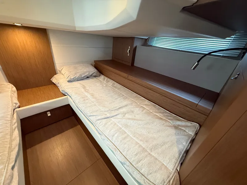 Slide: The Image of Cabin with two single beds, wood paneling, and a window with blinds. - 33