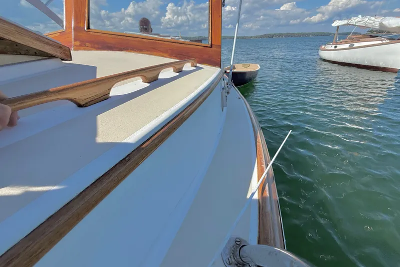 Slide: The Image of 1978 Wasque 26 boat on calm water with clear sky and distant shoreline. - 23