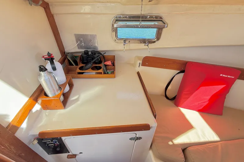 Slide: The Image of Interior of a 1978 Wasque 26 boat with storage and seating area. - 13