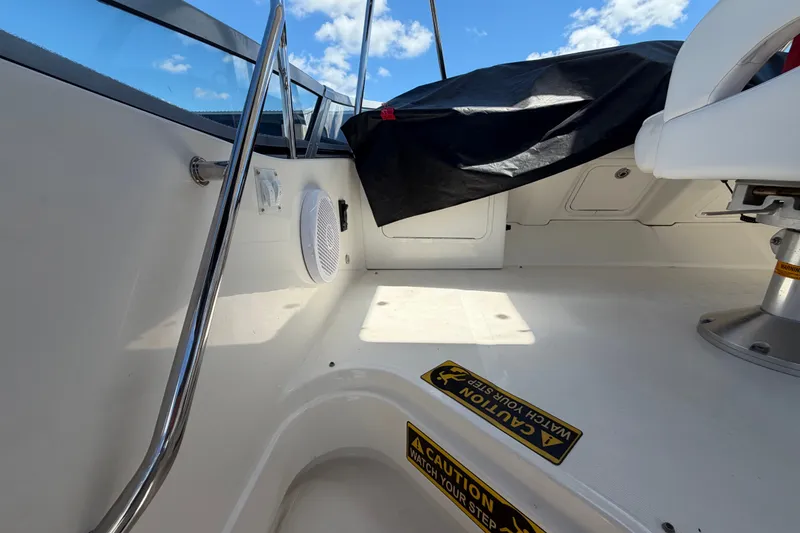 Slide: The Image of Interior view of 2010 Sea Ray 390 Sedan Bridge boat, featuring seating and caution signage. - 30