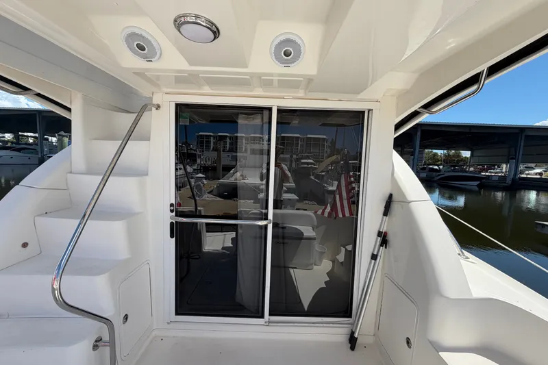 Slide: The Image of 2010 Sea Ray 390 Sedan Bridge yacht with sliding glass doors and staircase, docked at marina. - 11