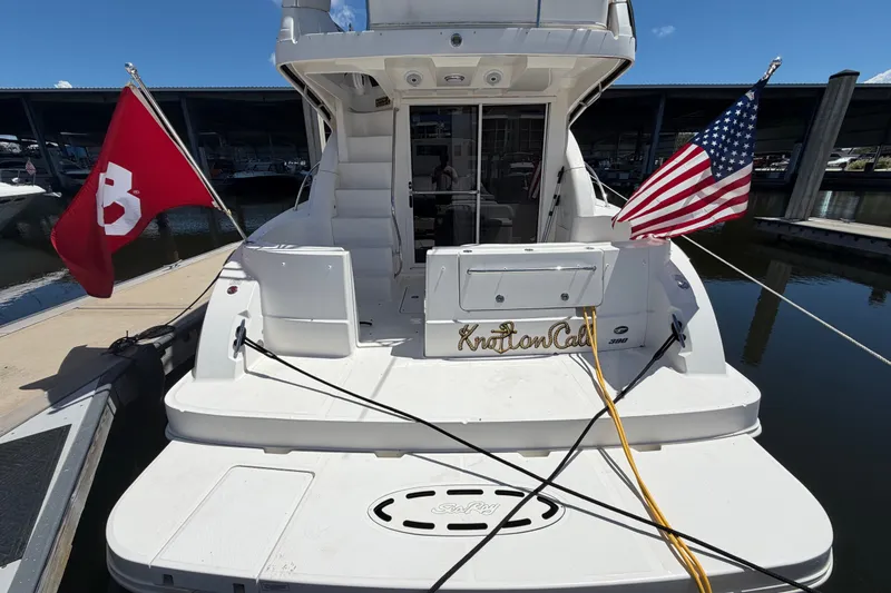 Slide: The Image of 2010 Sea Ray 390 Sedan Bridge docked, displaying American and red flags. - 14