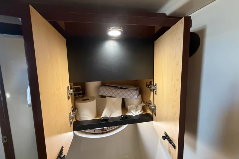 Slide: The Image of Open cabinet in 2010 Sea Ray 390 Sedan Bridge, storing paper towels and tissues. - 122