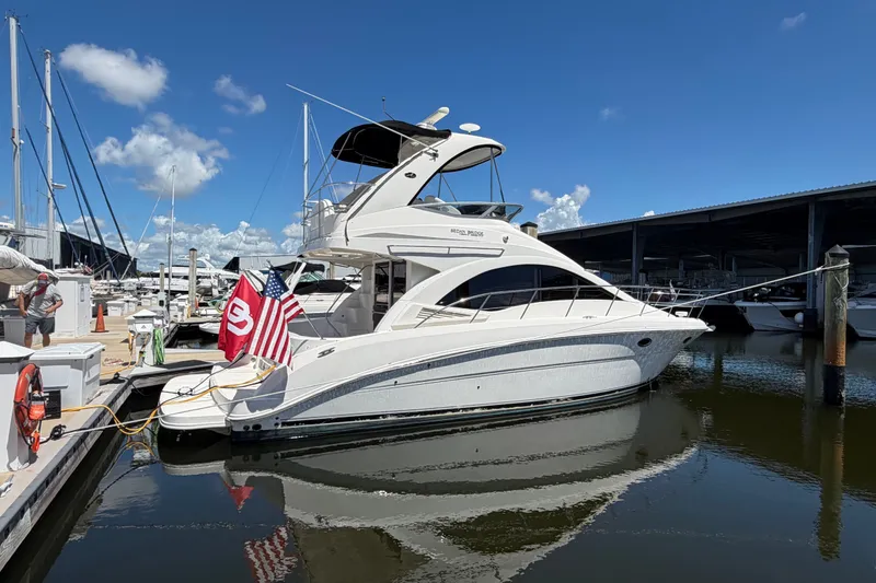 Slide: The Image of 2010 Sea Ray 390 Sedan Bridge yacht docked at marina under clear blue sky. - 3