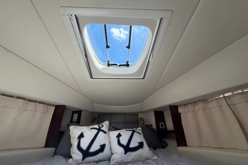 Slide: The Image of Interior cabin of 2010 Sea Ray 390 Sedan Bridge with skylight and anchor-themed pillows. - 103