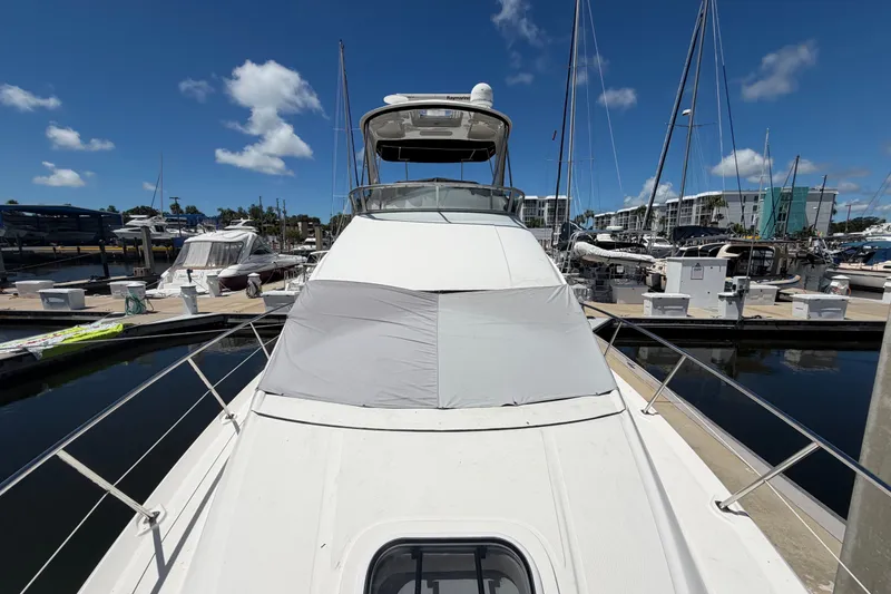 Slide: The Image of 2010 Sea Ray 390 Sedan Bridge yacht docked at marina under clear blue sky. - 8