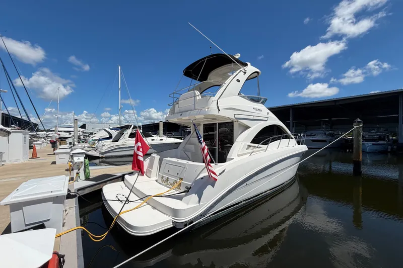 Slide: The Image of 2010 Sea Ray 390 Sedan Bridge yacht docked at marina under clear blue sky. - 2